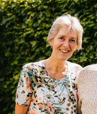 Het echtpaar Anja en Theo staan lachend in hun tuin op de foto